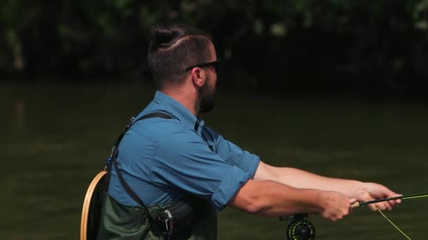 Visser gooit een vlotter, een man vissen op de rivier, staande in het water — Stockvideo