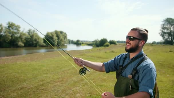 Mann fischt, angeln, Angelrute in der Hand, Köder spannen, Spinnrolle — Stockvideo