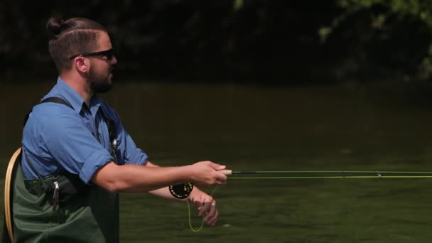 Pescador lanza una carroza, un hombre pescando en el río, de pie en el agua — Vídeos de Stock