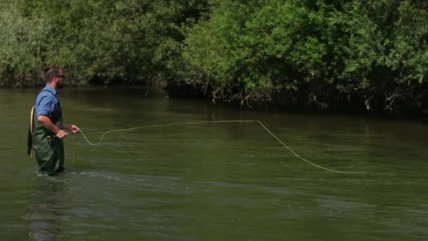 Pescador lanza una carroza, un hombre pescando en el río, de pie en el agua — Vídeo de stock