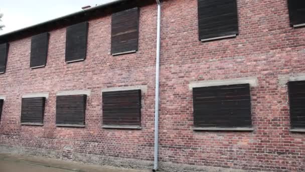 Two-storey building of red brick, whose Windows are clogged with dark boards — Stockvideo