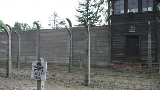 Beveiligings toren van donker hout en oude tegels, die achter hek van prikkeldraad is — Stockvideo