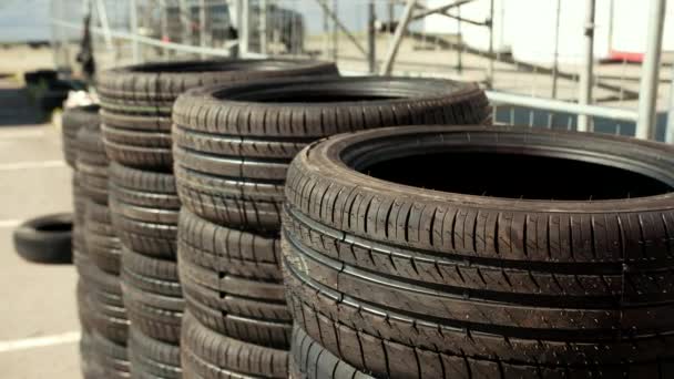 Very many new tires for cars, racing drift, standing on the asphalt stacks — Stock Video