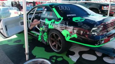 green sports passenger car, man with a laptop that configures the auto