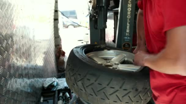 Een man op een speciale machine voor, Tire service, verander het rubber op de schijf — Stockvideo