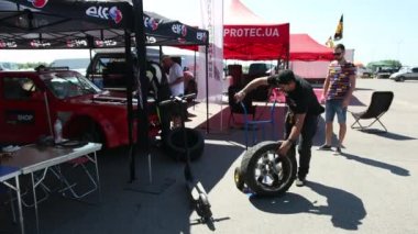 siyah giysiler ve bir şapka bir adam, sitede tekerlekler koyar