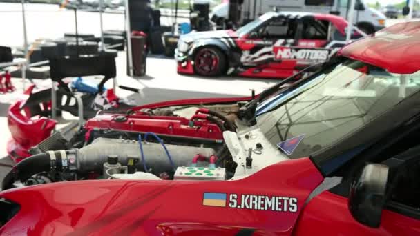 Capot ouvert voiture de sport rouge pour la course de dérive de rue, au milieu d'un gros moteur — Video