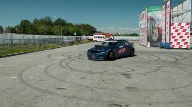 iki genç adamın ortasında, sürüklenen sokak yarışı için mavi spor araba gider