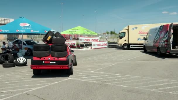 Fährt roten Sportwagen für Rennen, auf dem Dach des Autos viele neue Reifen — Stockvideo