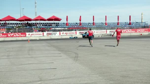 Dos jóvenes corrieron al coche de carreras de deportes azules, que se salió de la carretera — Vídeos de Stock