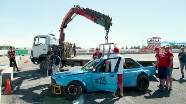 Laweta podnosi niebieski rozbił samochód sportowy, który poszedł z toru — Wideo stockowe