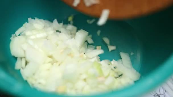 Mujer corta en una tabla de madera, cuchillo verde, pequeños trozos de cebolla — Vídeos de Stock