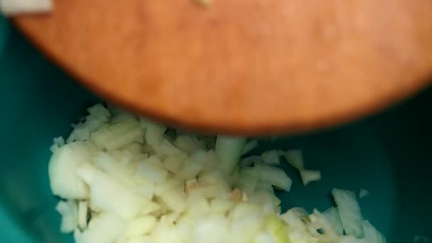 Kadın ahşap bir tahta, yeşil bıçak, soğan küçük parçalar üzerinde keser — Stok video