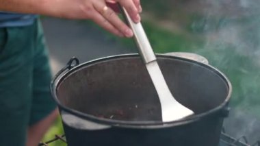 insanlar büyük bir demir tencerede çanak büyük, metalevel, mutfak spatula çanak karıştırır