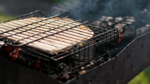 Mann auf dem Grill, auf kleinem Feuer ein großes Fladenbrot braten — Stockvideo