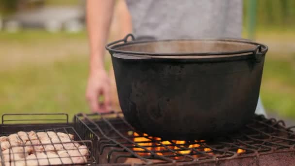 Mensen bereiden maaltijden op de grill bij een picknick, prachtige natuur — Stockvideo