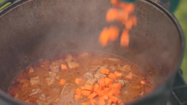 Büyük dökme demir tencerede yemek hazırlama, et soğan ve diğer bileşenleri ile kırmızı — Stok video