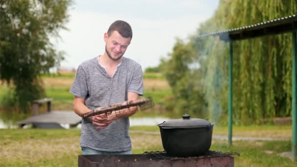 Οι άνθρωποι που ετοιμάζουν τα γεύματα στη σχάρα σε ένα πικ-νικ, όμορφη φύση — Αρχείο Βίντεο