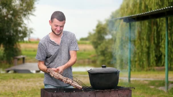 Lidé připravují jídlo na grilu na pikniku, nádherné přírodě — Stock video