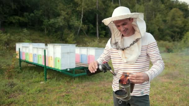 Imker in spezieller Kleidung mit Raucher zur Beruhigung der Bienen — Stockvideo