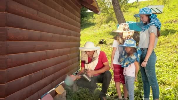 Pszczelarz w specjalnych ubrań dla pszczelarstwa, trzymając palacz, aby uspokoić pszczoły — Wideo stockowe