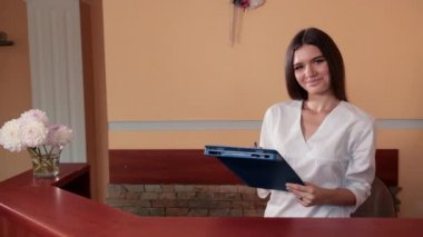 tıbbi cüppe hemşire resepsiyonda kadın müşteriye tavsiye sağlar