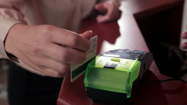 Une cliente en chemisier beige est payée par carte — Video