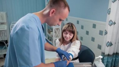 doktor bir kadın hastanın kolunda bir enjeksiyon yapar