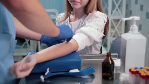 Médecin mouillant coton avec de l'alcool, patiente assise en attente de tests — Video