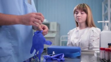 tek kullanımlık eldiven giyen erkek doktor, kadın hasta testleri bekliyor oturuyor