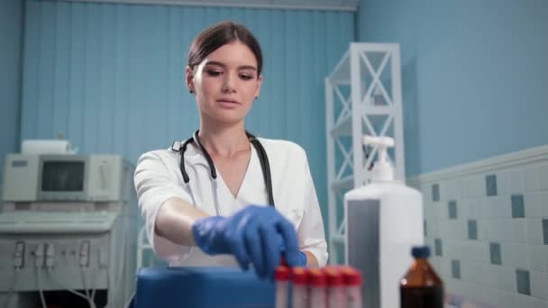 Enfermero médico sosteniendo un tubo de ensayo, examina cuidadosamente — Vídeo de stock