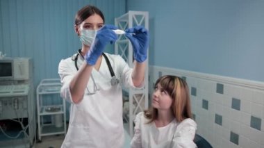 hemşire doktor genç bir kadının termometre vücut ısısını kontrol eder