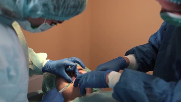 Лікарня, хірургічне відділення, лікарі та медсестри проводять операцію — стокове відео