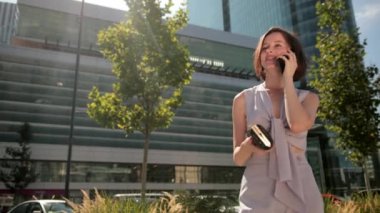 İş, genç kadın, esmer, elinde akıllı bir telefonla konuşmak, pozitif tavır.