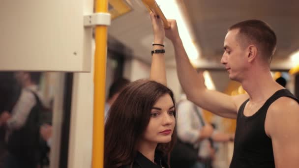 Транспорт. двое молодых людей едут в метро, крупным планом, замедленной съемки — стоковое видео