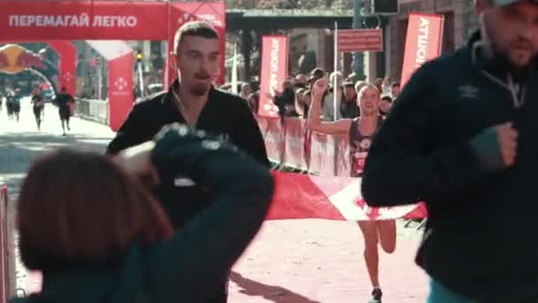Молодой спортсмен бежит через финишную черту, финишируя в марафоне . — стоковое видео