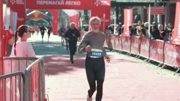 Farfar till atletisk byggnad med grått skägg slutar i ett springande maraton. — Stockvideo