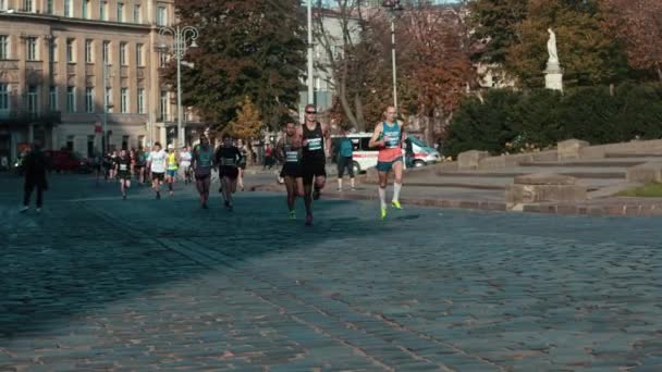 Sportler rennen durch die Straßen der Stadt — Stockvideo