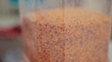 bir çok küçük renk, turuncu, sarı, kahverengi granüller plastik kabın içinde