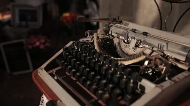Egy öreg írógépet, ami fehér kötött asztalterítővel áll az asztalon. — Stock videók