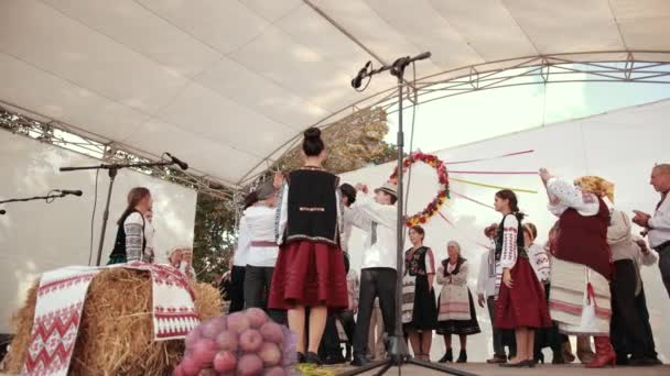 在白人舞台上表演，穿着民族服装的男男女女，唱歌跳舞 — 图库视频影像