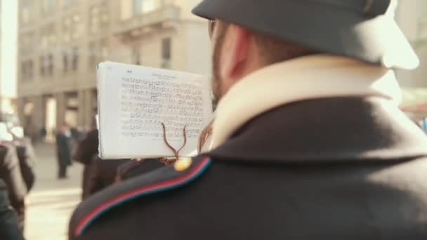 Музыкант смотрит на лист, бумагу с записками, играет на духовом инструменте, тубе. Назад — стоковое видео