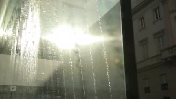 Street Fountain. Des jets d'eau pulvérisent, tombent sur le verre, le soleil brillant brille derrière — Video