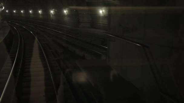 Тёмный подземный тоннель, в глубине души, вагон метро едет по рельсам в метро — стоковое видео