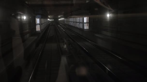 Tunnel de train souterrain sombre, au fond, des promenades en métro en voiture sur les rails dans le métro — Video