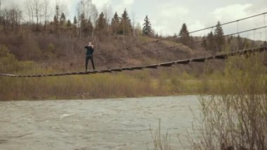 Köprüde kemancı, sokak sanatçısı, dışarıda keman çalıyor. hızlı nehir