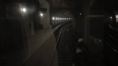 Karanlık yeraltı tren tüneli, derinlerde, metro vagonu raylarda ilerliyor.