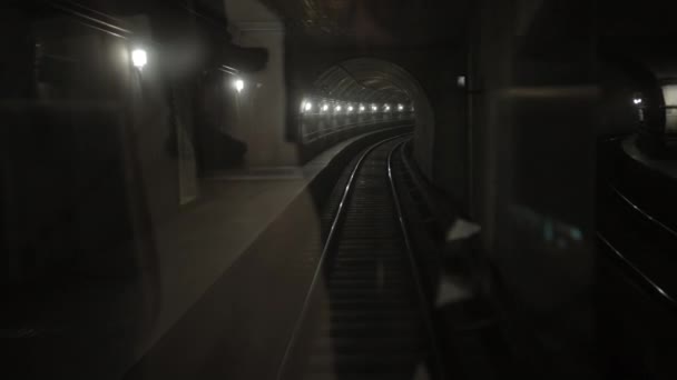 Túnel de tren subterráneo oscuro, en el fondo, vagones de metro sobre raíles en el metro — Vídeo de stock