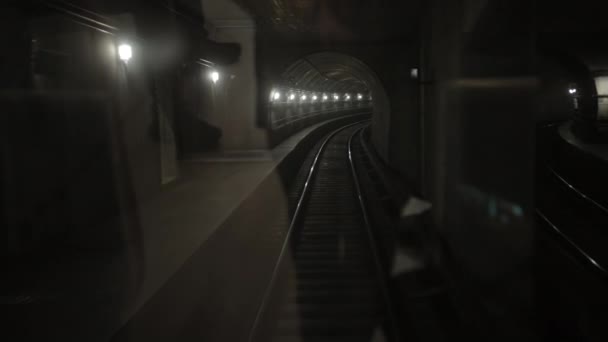 Túnel de tren subterráneo oscuro, en el fondo, vagones de metro sobre raíles en el metro — Vídeos de Stock