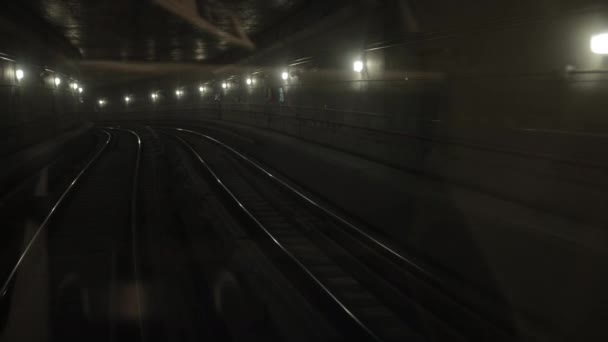 Túnel de tren subterráneo oscuro, en el fondo, vagones de metro sobre raíles en el metro — Vídeos de Stock